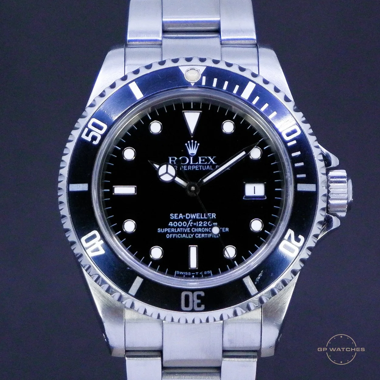 Close-up of a stainless steel Rolex Sea-Dweller Watch with a black dial, rotating bezel, and date display.