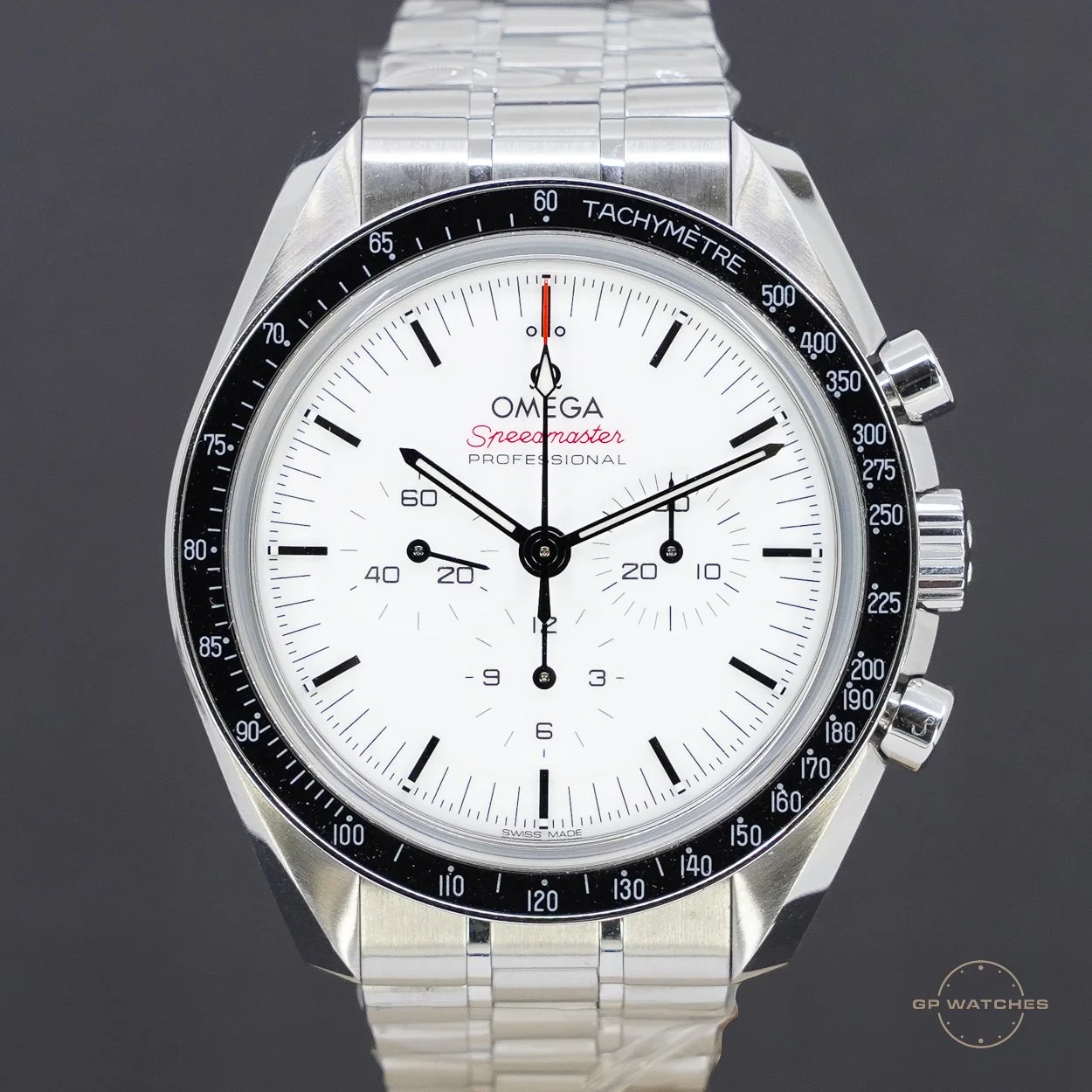 A close-up of an Omega Speedmaster Professional watch with a white dial, black tachymeter bezel, and a stainless steel bracelet.