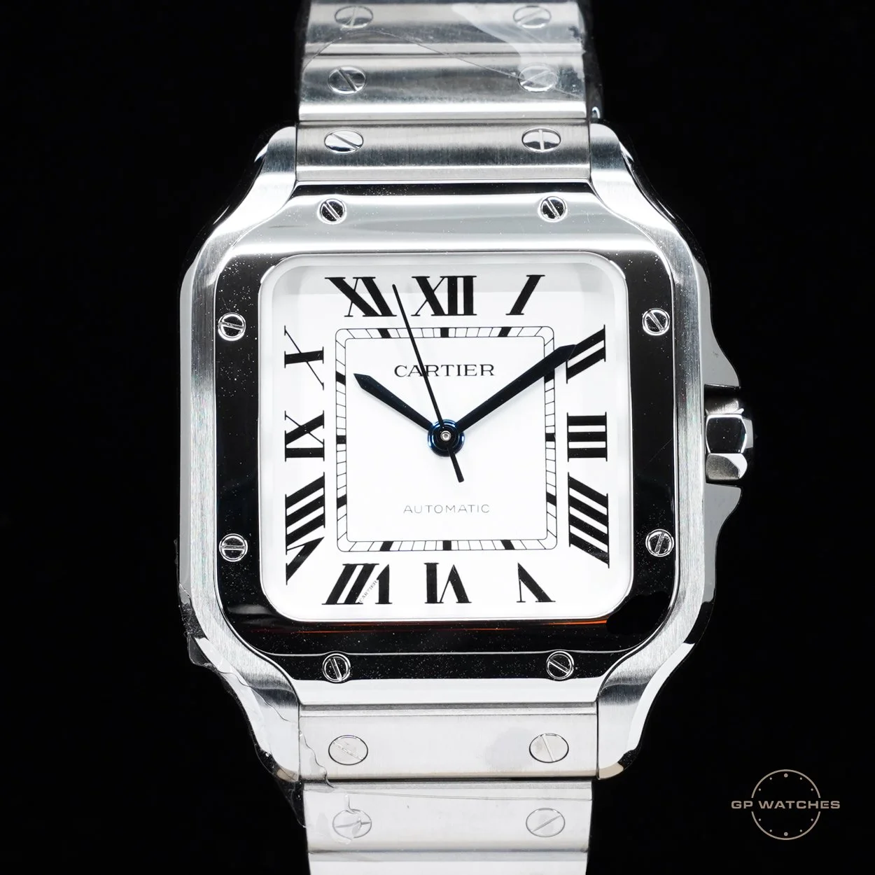 A luxury Cartier wristwatch with a round silver metal band and a square face featuring Roman numerals and black hands, against a black background.