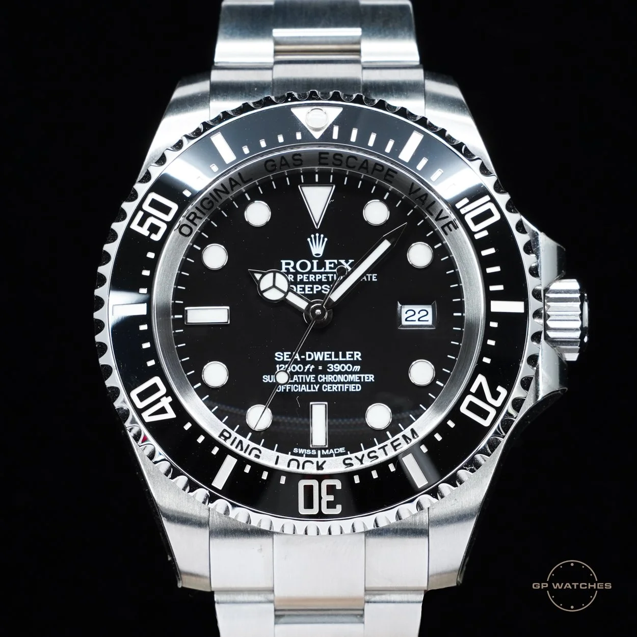 A close-up image of a Rolex Sea-Dweller Deepsea stainless steel wristwatch with a black dial, rotating bezel, and date display.
