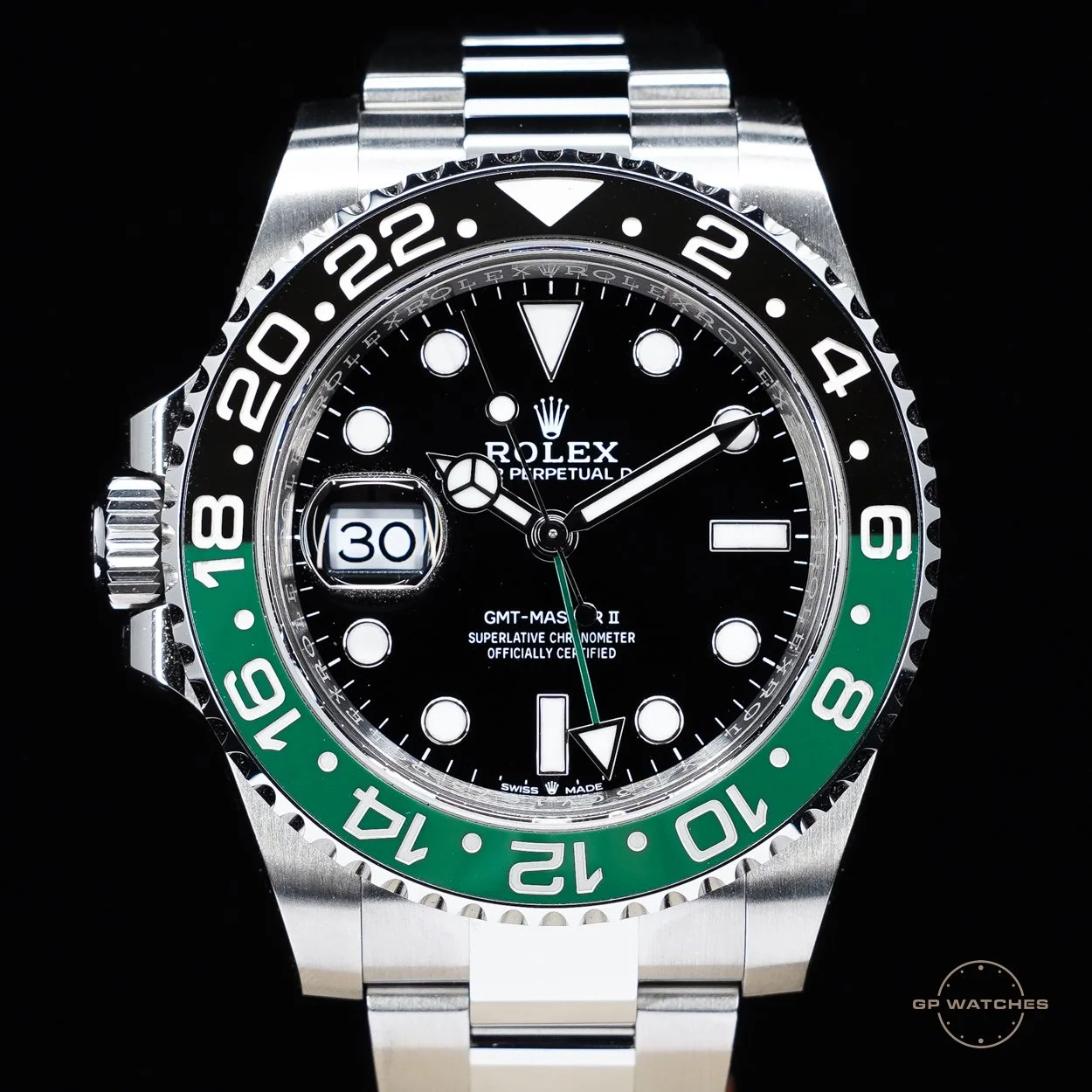 Close-up of a Rolex GMT-Master II watch with a black dial, green and black bezel, silver bracelet, and date display.