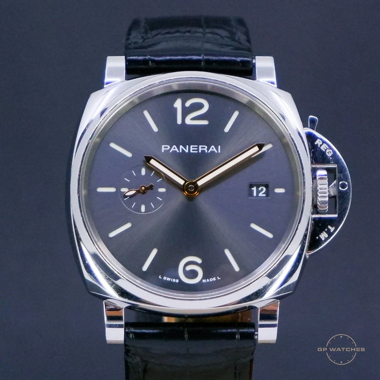 Close-up of a Panerai luxury wristwatch with a black leather strap, a silver case, a dark gray dial, large luminous numerals at 12 and 6, a small seconds subdial on the left, and a date window at 3 o'clock.