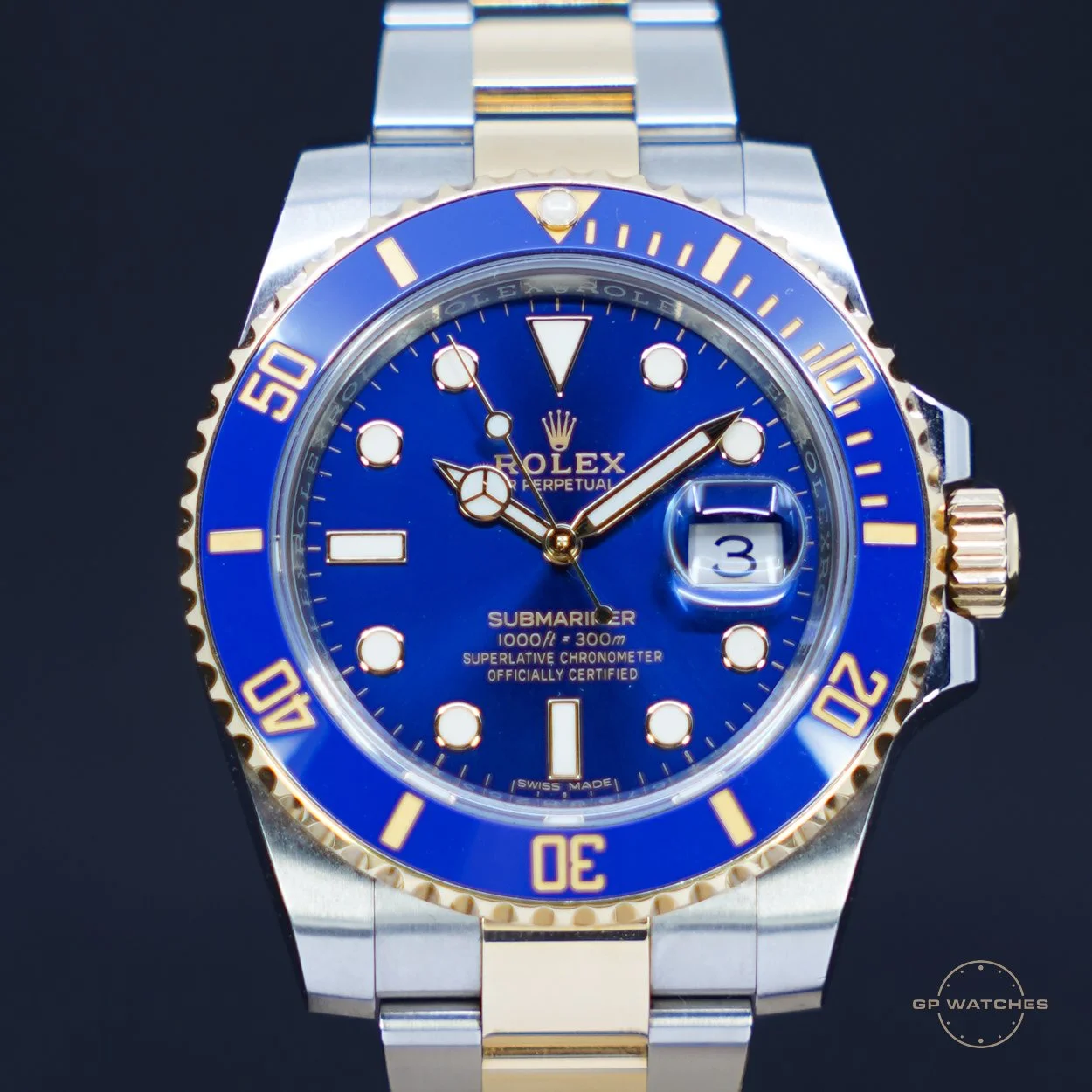 A Rolex Submariner wristwatch with a blue dial, gold and silver band, and a blue bezel displaying time and date.
