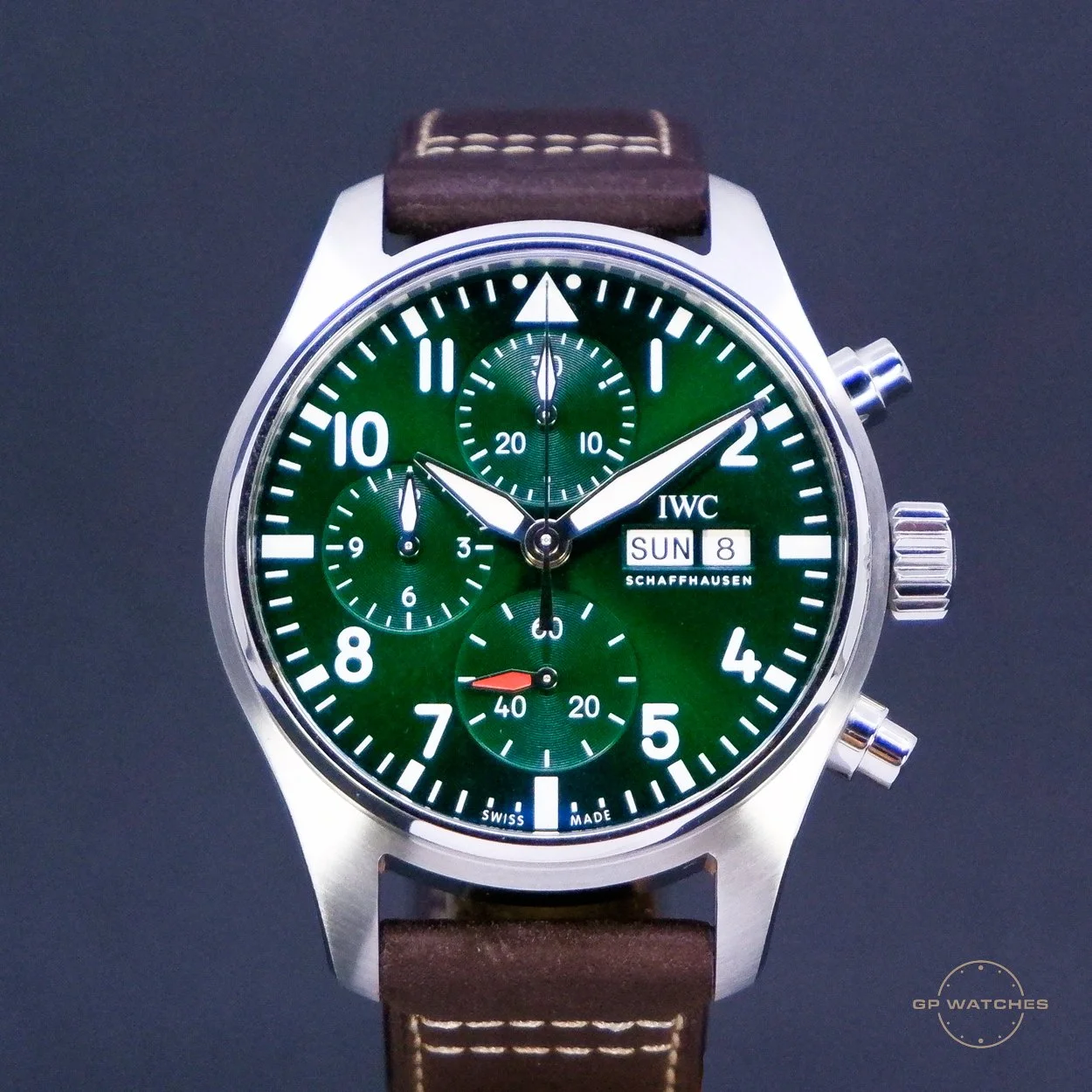 A wristwatch with a green dial, silver case, brown leather strap, and multiple chronograph sub-dials, with day and date display.