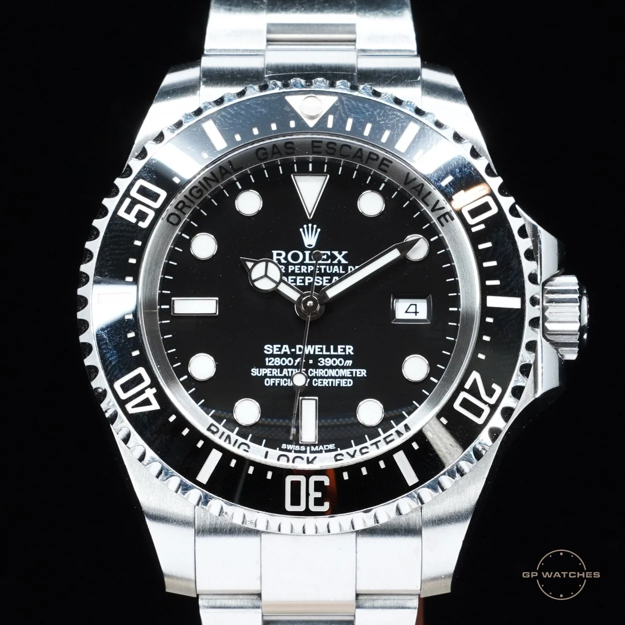 A close-up photo of a Rolex Sea-Dweller Deepsea wristwatch with a black dial, silver bezel, and a silver metal band.