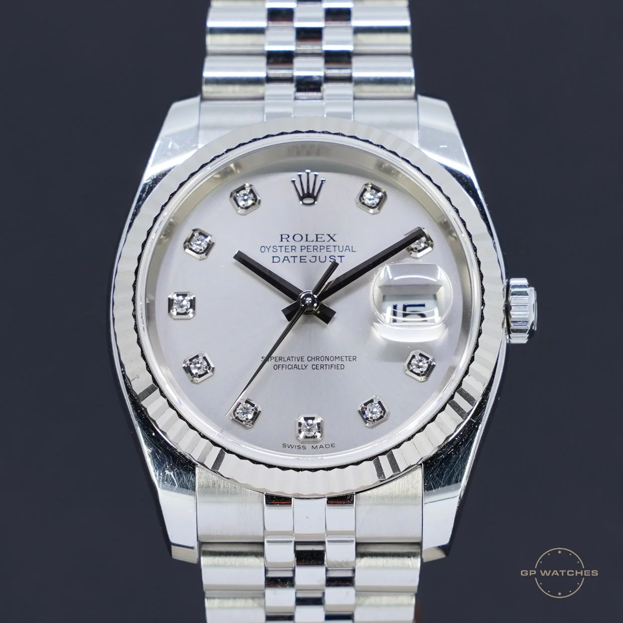 Close-up of a silver Rolex Datejust watch with a white dial, diamond hour markers, and a date display at 3 o'clock on a black background.