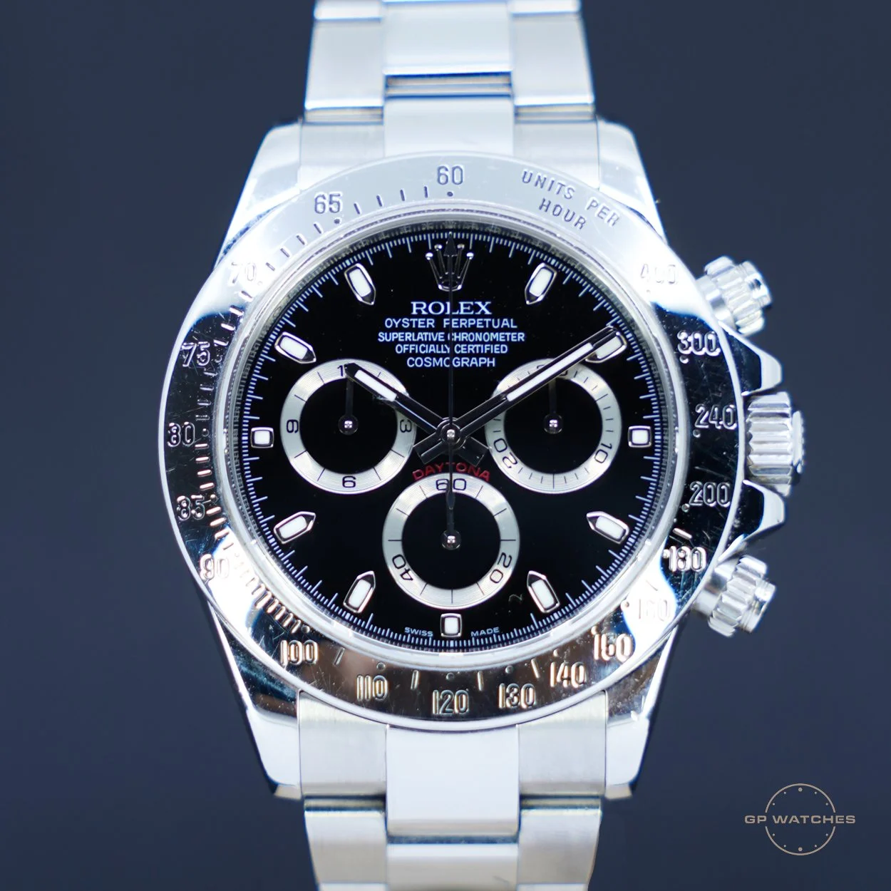 A luxury Rolex Oyster Perpetual Cosmograph Daytona watch with a black dial and silver stainless steel bracelet, featuring three sub-dials and a tachymeter scale on the bezel.