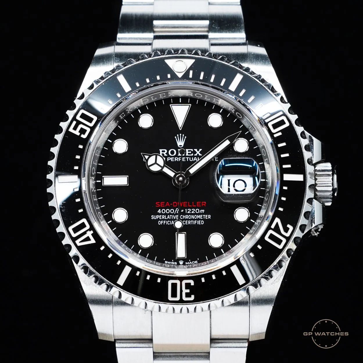 A Rolex Sea-Dweller wristwatch with a black dial, white markers, and a date window at 3 o'clock, featuring a stainless steel bracelet and bezel.