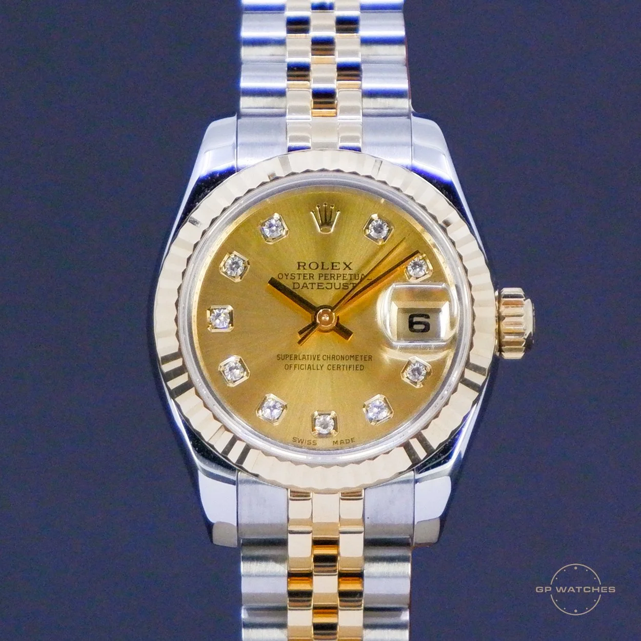 A two-tone Rolex Datejust wristwatch with a gold dial, diamond hour markers, and a stainless steel and gold bracelet, featuring a date window at 3 o'clock.