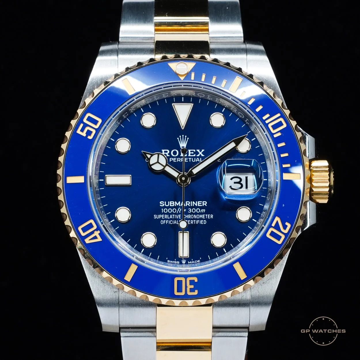 A Rolex Submariner wristwatch with a blue dial, a blue and gold bezel, and a stainless steel and gold bracelet.