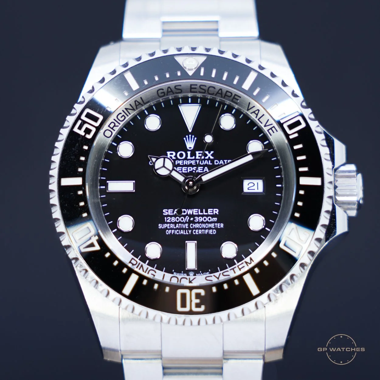 Close-up of a Rolex Deepsea Sea-Dweller wristwatch with a black dial, silver bezel, and stainless steel band, showing the time, date, and depth rating.