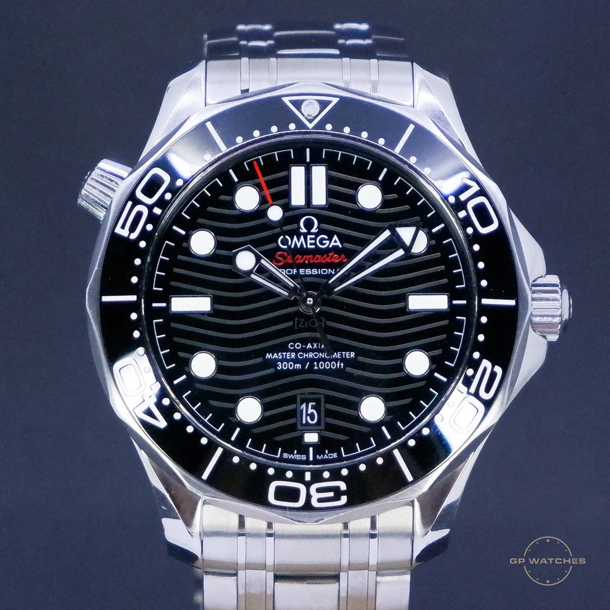 A close-up image of an Omega Seamaster Professional wristwatch with a black dial, white markers, and a stainless steel band. The watch has a rotating bezel with minute markers, a date window at 6 o'clock, and hands for hours, minutes, and seconds, featuring a red tip and a red second hand. The brand name, model, and specifications are visible on the dial.