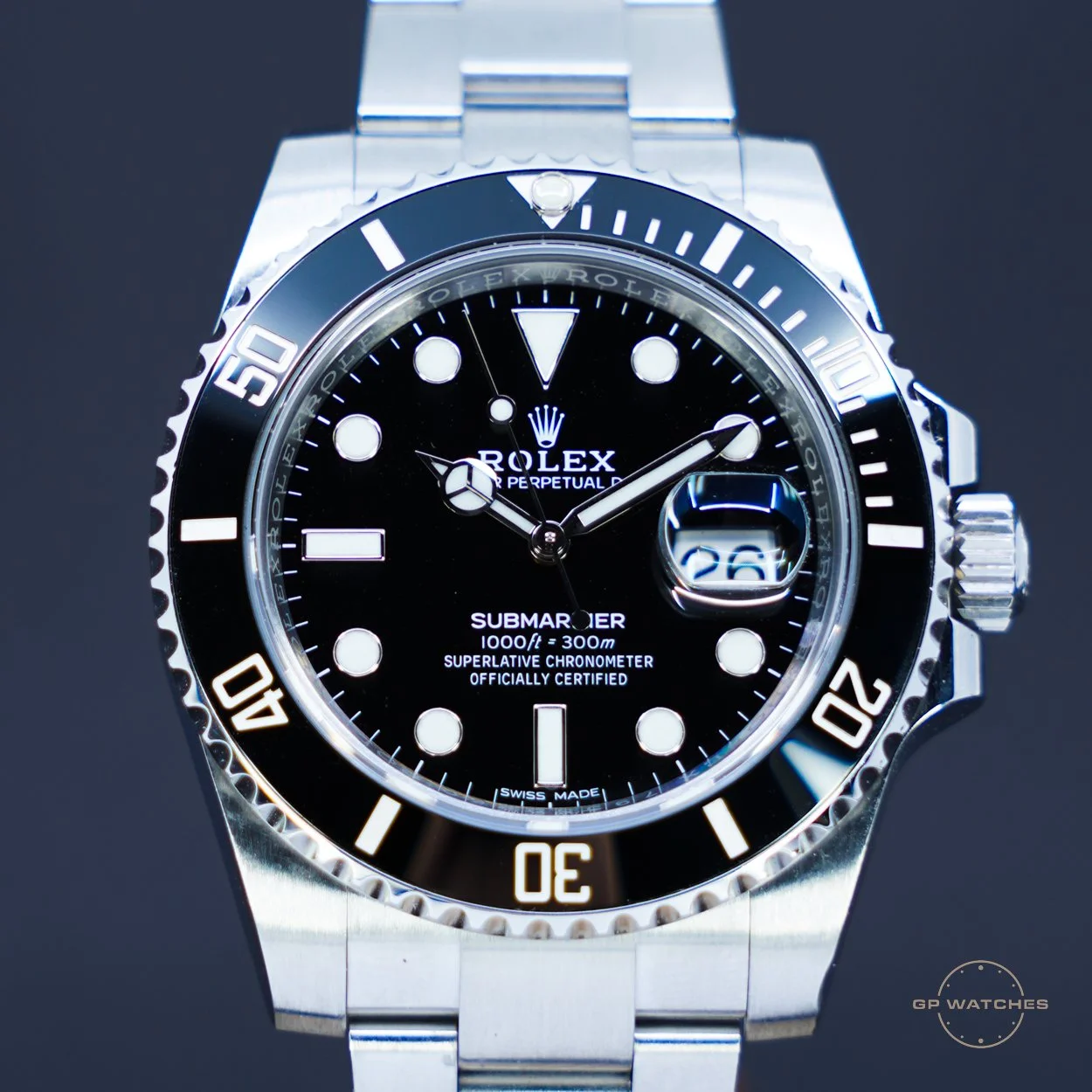 Close-up of a Rolex Submariner watch with a black dial, silver bezel, and date display at 3 o'clock.