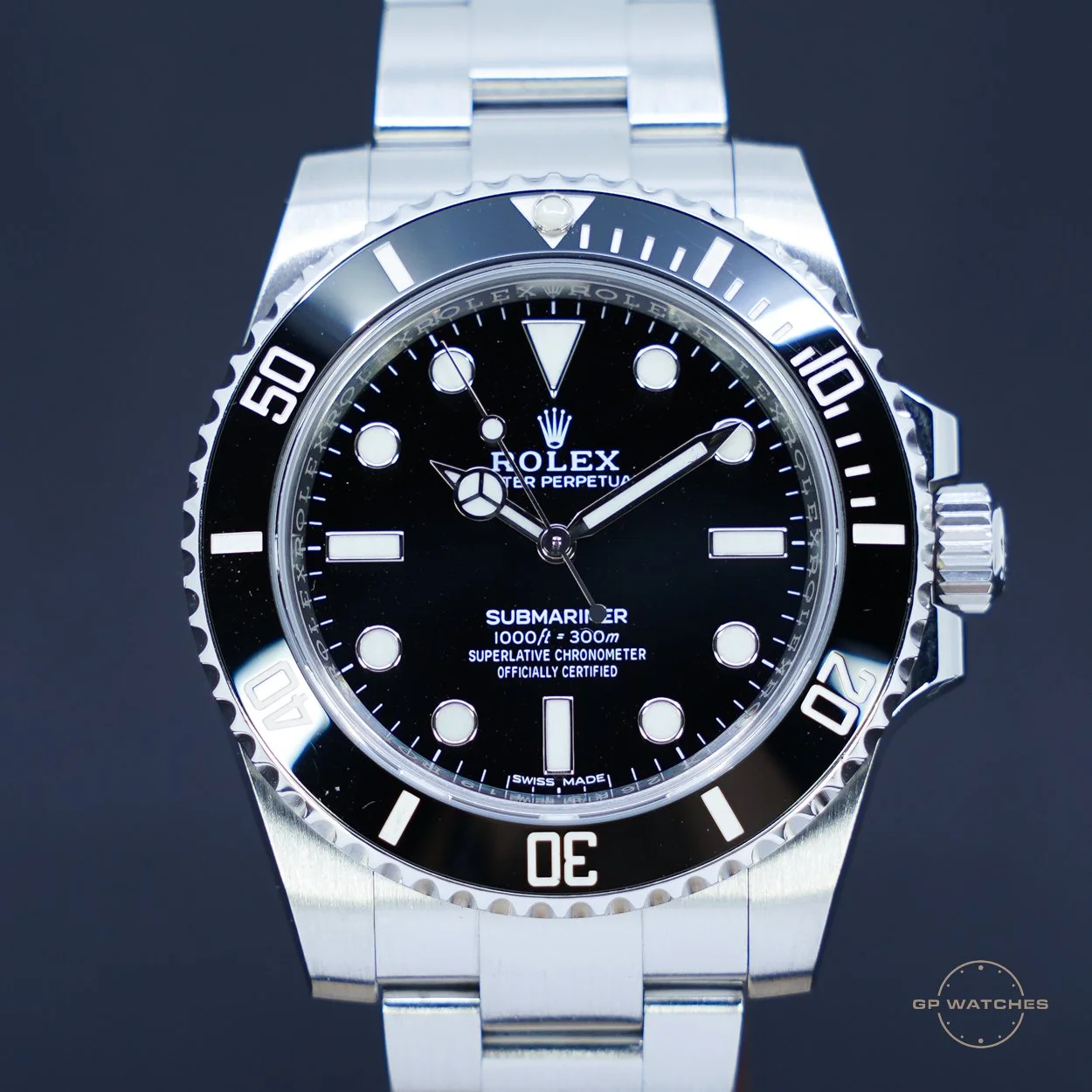 Close-up of a Rolex Submariner watch with a black dial, luminous hour markers, and a rotating black bezel with minute markers, attached to a stainless steel bracelet.