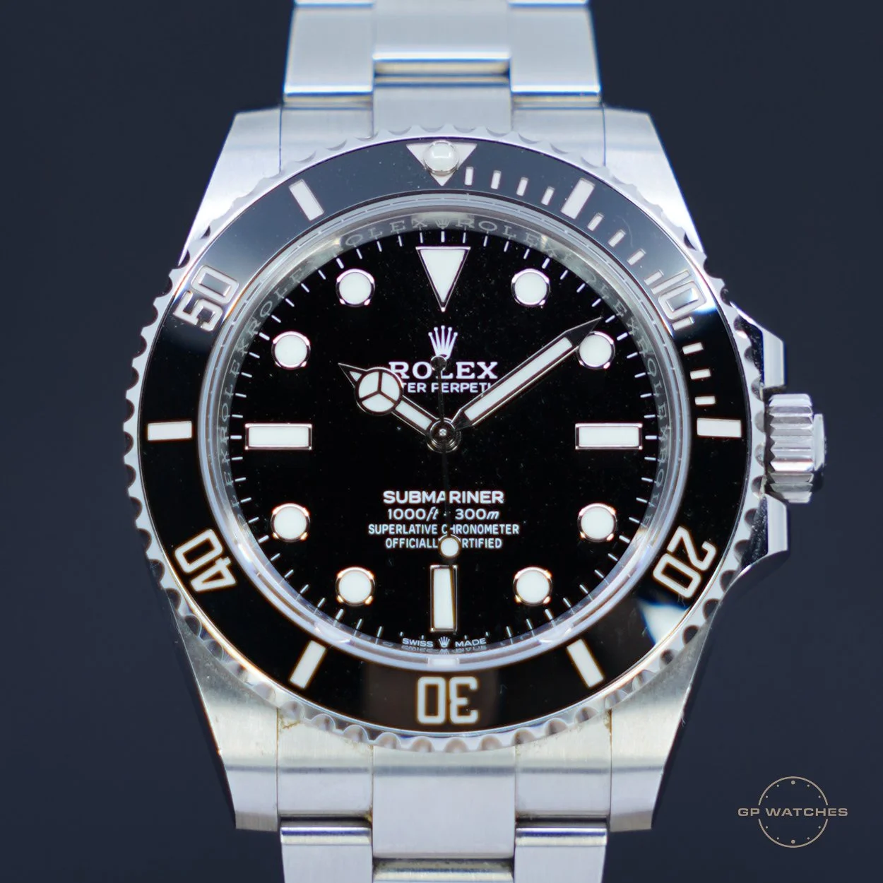 Close-up view of a Rolex Submariner watch with a black dial, luminous markers, and a unidirectional bezel, on a stainless steel bracelet.