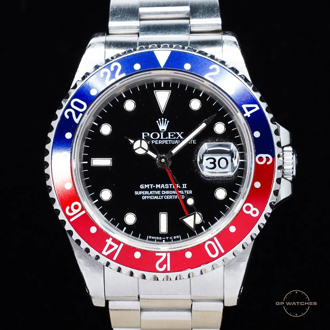 Close-up of a Rolex GMT-Master II watch with a black dial, a two-tone red and blue bezel, and a date window showing the number 30.