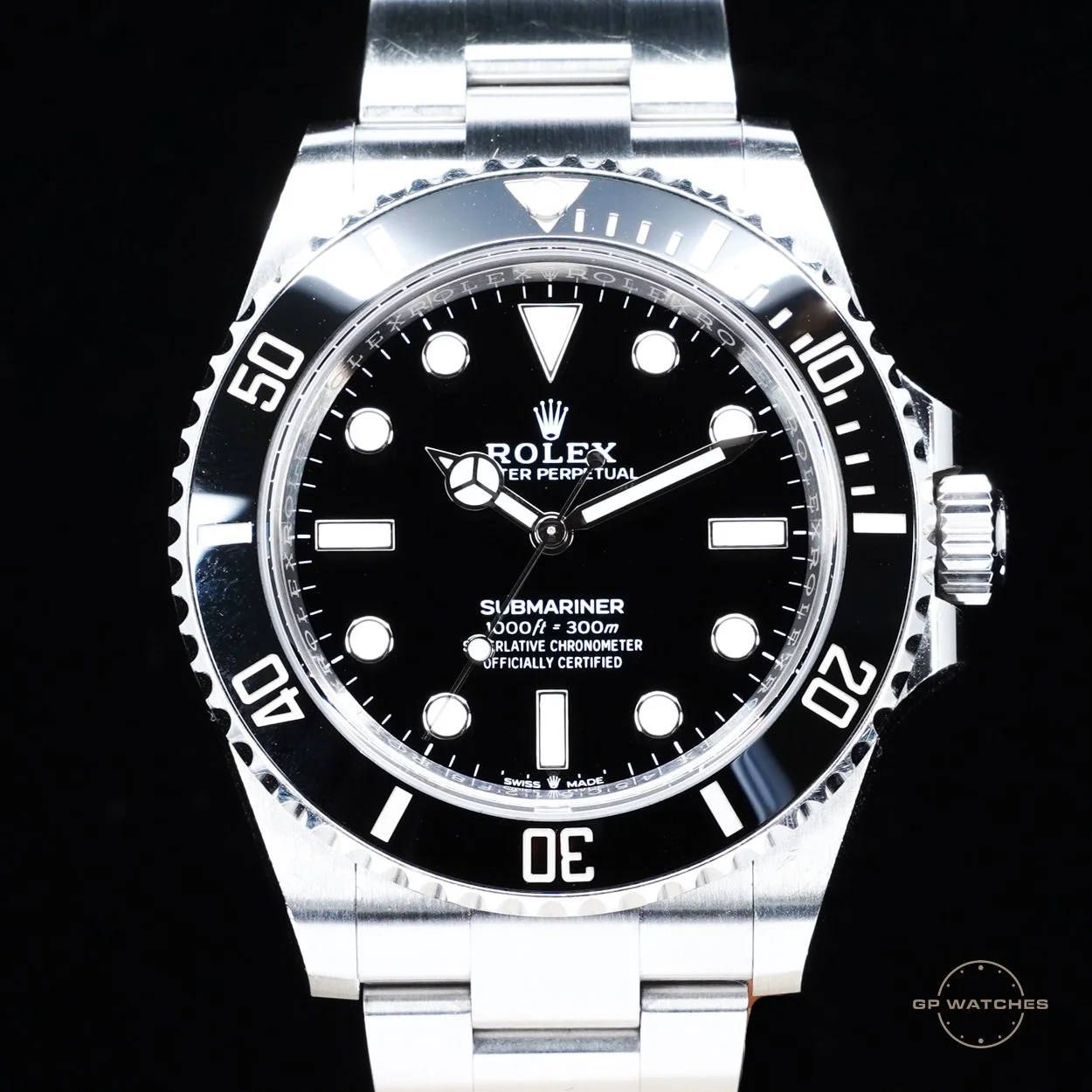 A close-up of a Rolex Submariner watch with a black dial and bezel, silver case, and metal bracelet, displaying the time and date.