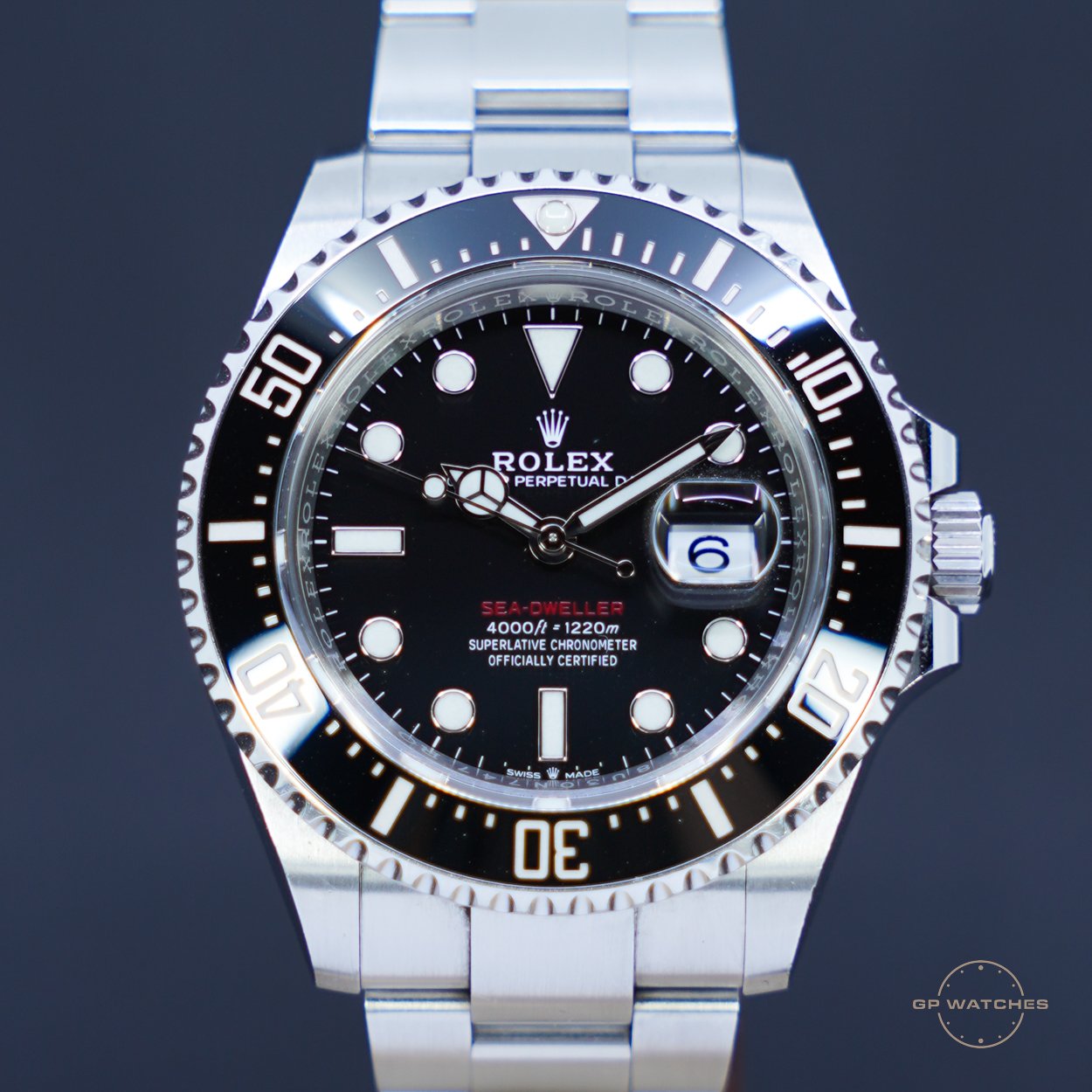 Close-up of a Rolex Sea-Dweller deep-sea diving watch with black dial, silver bezel, and stainless steel strap.
