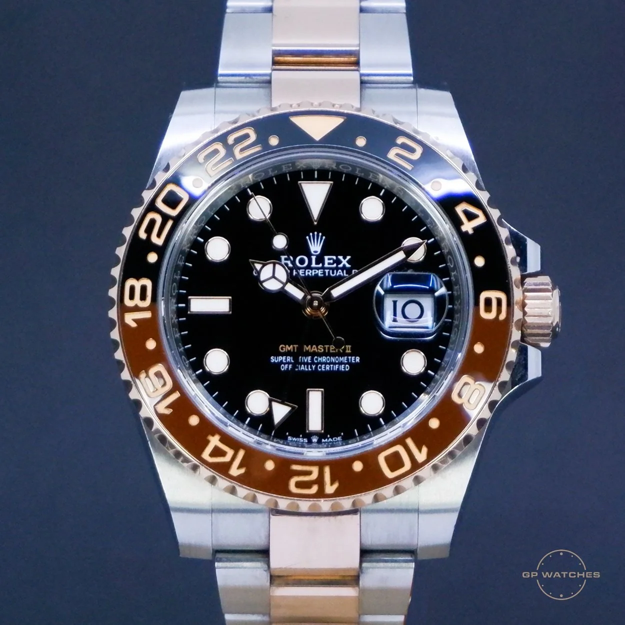 A Rolex GMT Master II wristwatch with a black dial, metal bezel, and two-tone bracelet.