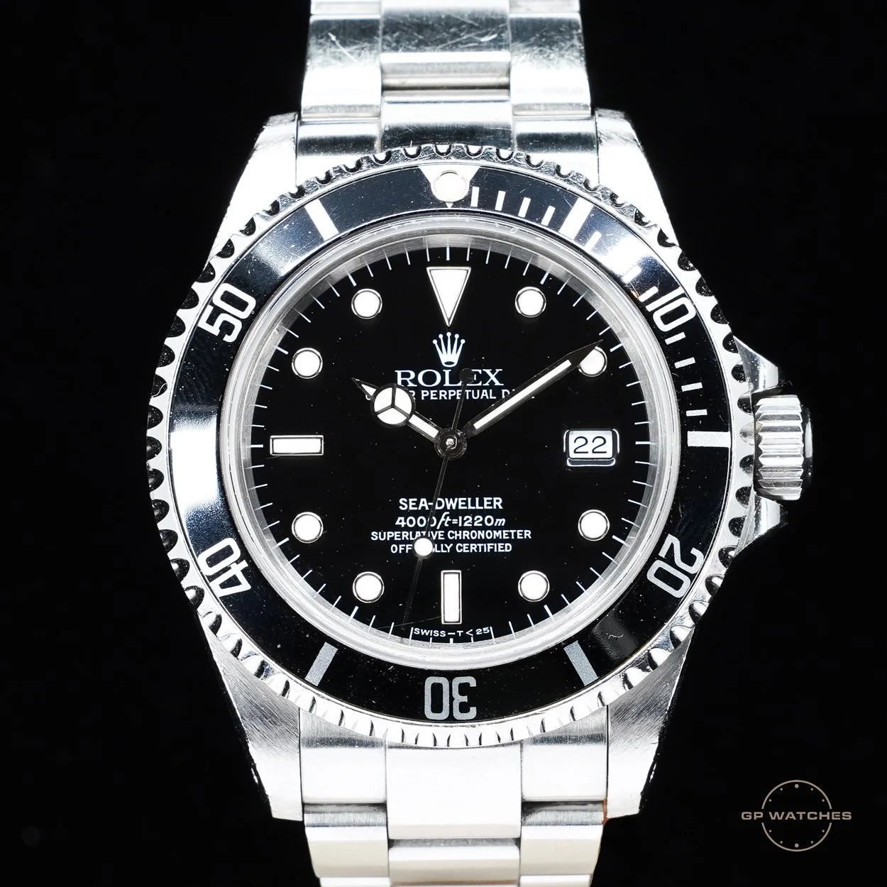 A Rolex Sea-Dweller wristwatch with a black dial, silver bezel, and stainless steel bracelet showing the time, date, and depth rating.