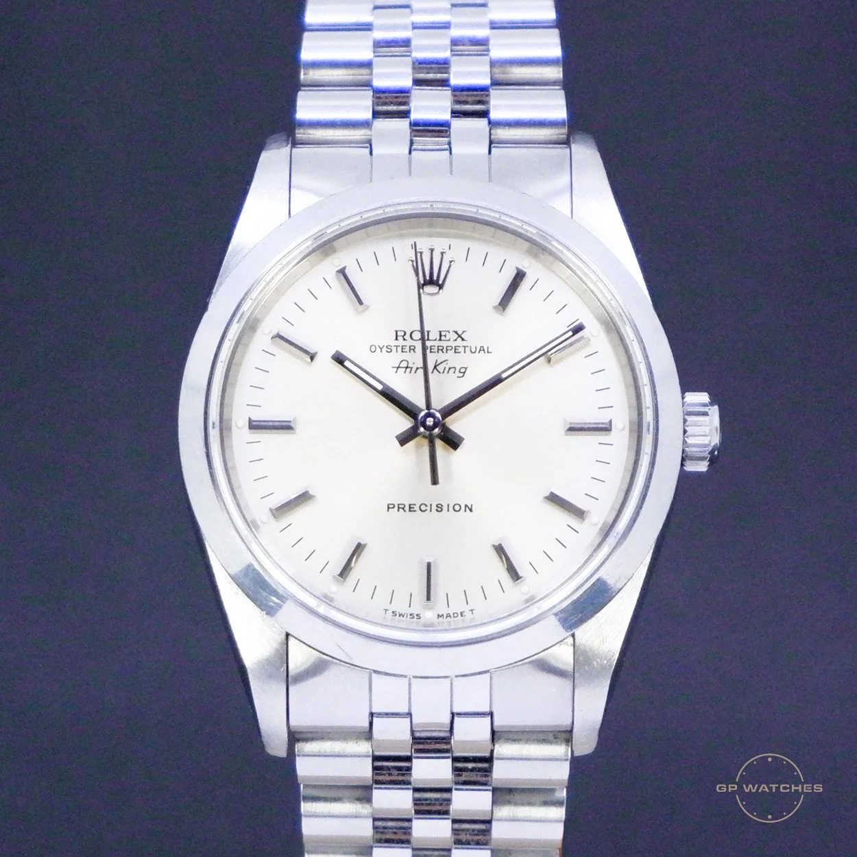 A silver Rolex Air King wristwatch with a white dial, silver hour markers, black hands, and a stainless steel bracelet, set against a black background.