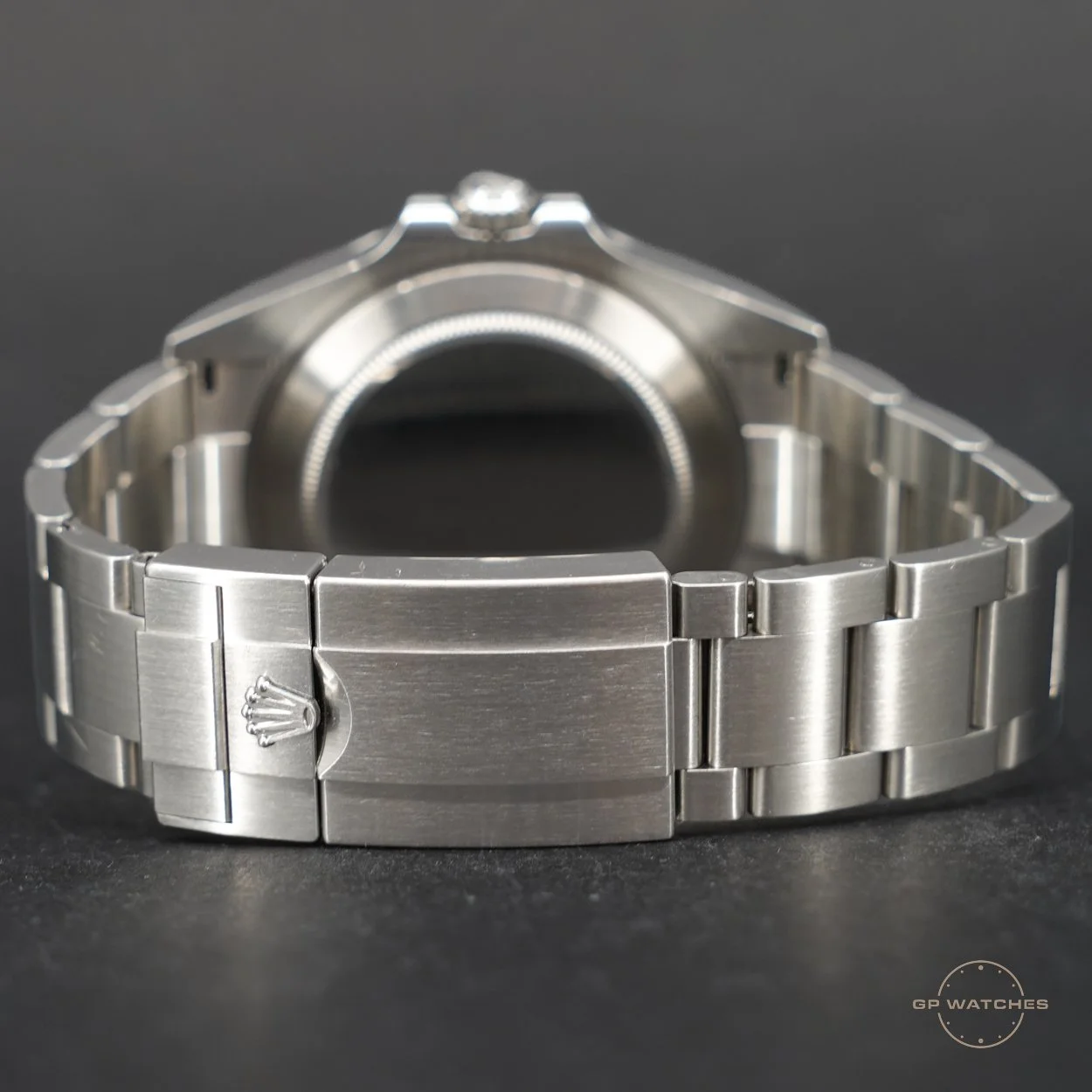 Close-up of a stainless steel Rolex watch bracelet with the Rolex crown logo on the clasp, viewed from the back side with the watch face not visible.