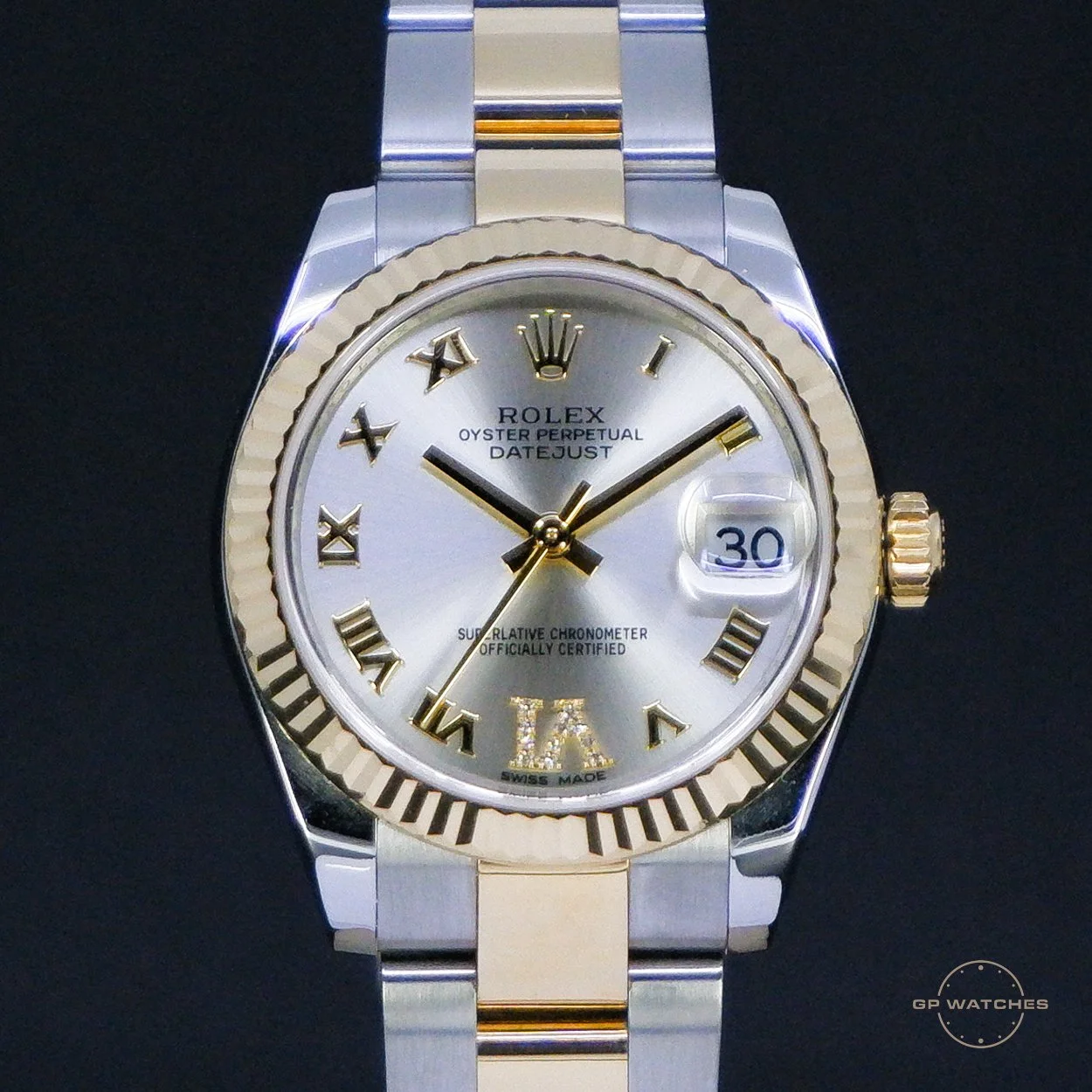 A close-up of a Rolex Oyster Perpetual Datejust watch with a silver face, gold Roman numeral hour markers, and a two-tone silver and gold bracelet, showing the date as 30.