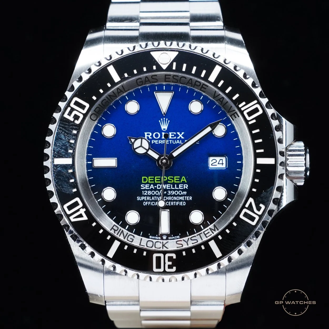 A Rolex Deepsea Sea-Dweller watch with a blue dial and a stainless steel bracelet, featuring a black unidirectional rotating bezel with white markings, and a date display at 3 o'clock.