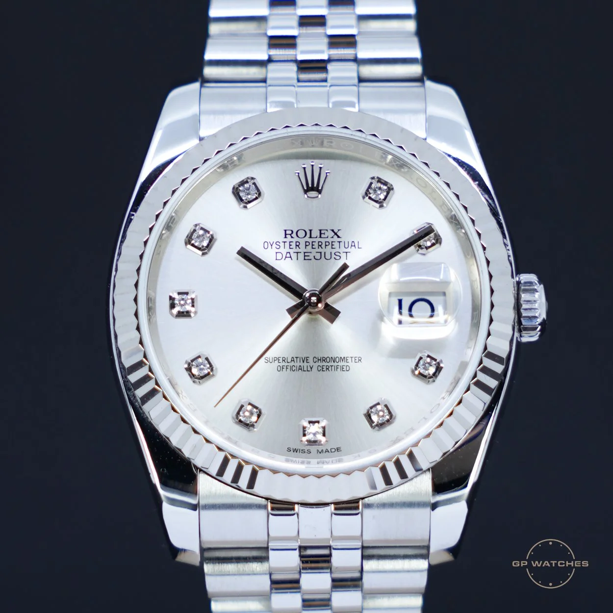 A silver Rolex Oyster Perpetual Datejust wristwatch with diamond hour markers and a fluted bezel, displaying the time and date on a black background.