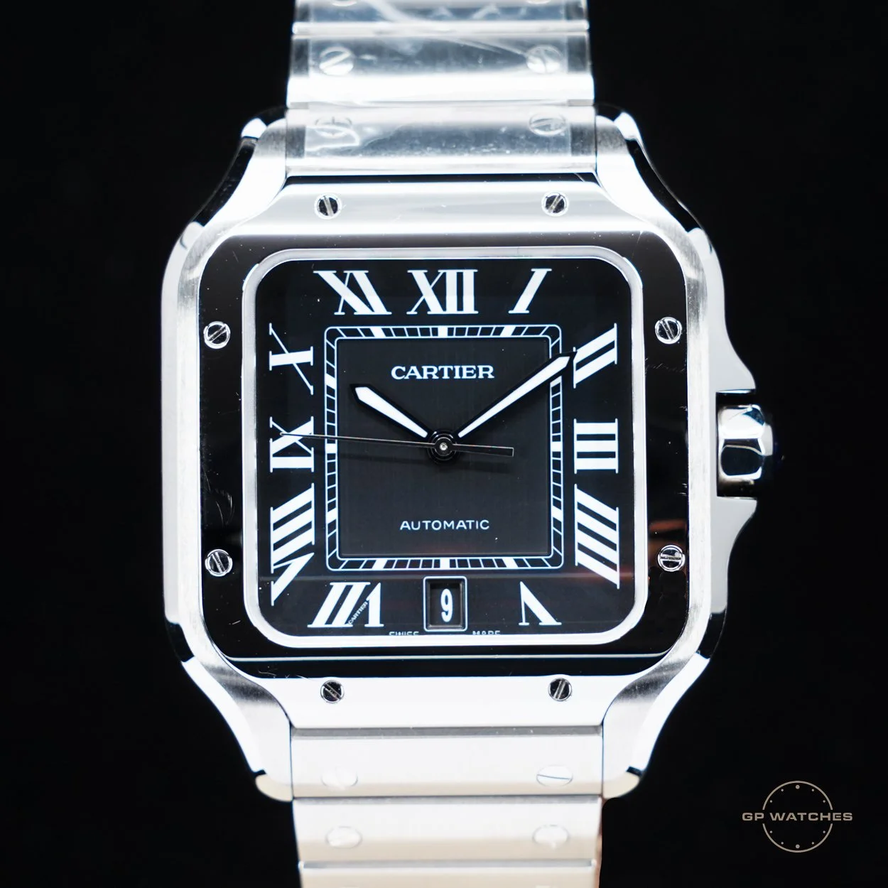 A luxury Cartier wristwatch with a silver metal band and a square black dial featuring Roman numerals and a date window at 6 o'clock.
