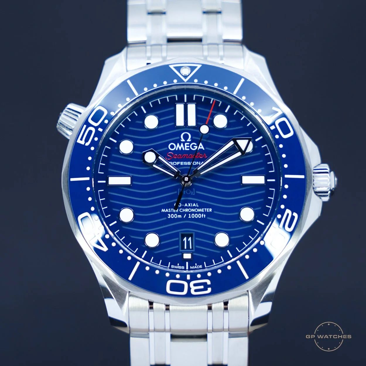 A blue Omega Seamaster Professional diving watch with a stainless steel bracelet, featuring a round dial with luminous markers, date display, and a unidirectional rotating bezel.