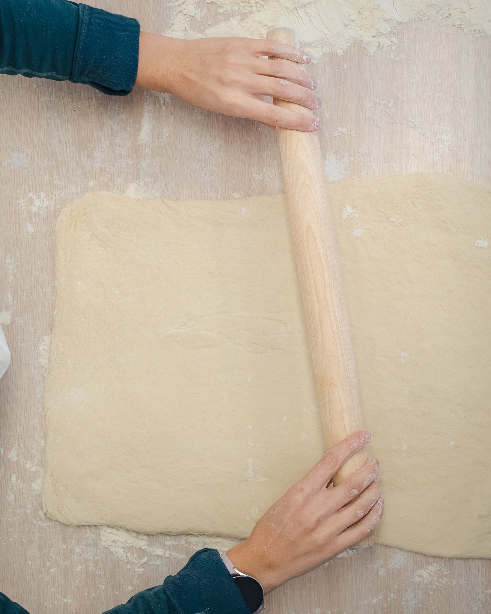 Baker rolling out pastry dough, shot overhead during a commercial food photography session in the Flathead Valley.