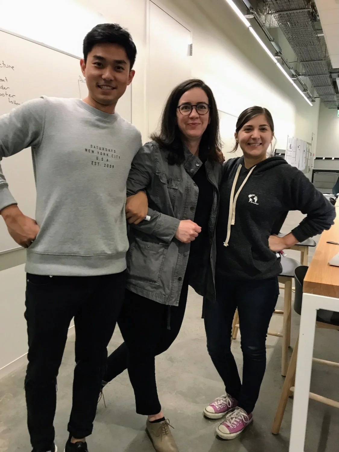 3 people standing in a row and smiling