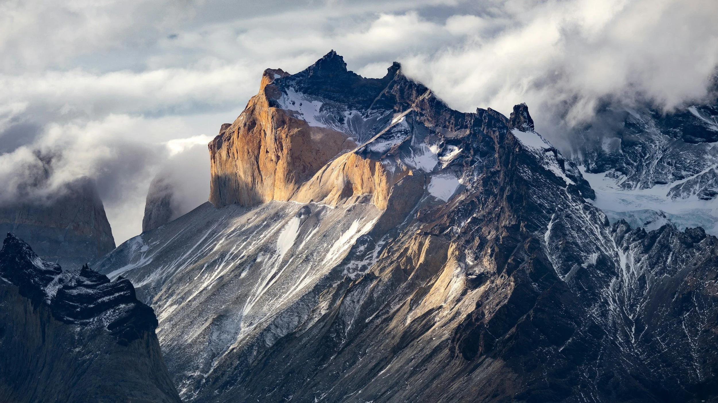 Mountain peaks covered in snow with clouds