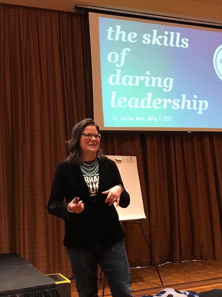 Individual presenting on 'The Skills of Daring Leadership' in a seminar room.