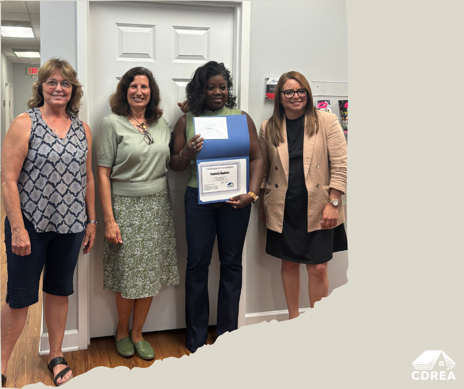 3 real estate school instructors with graduating student holding certificate