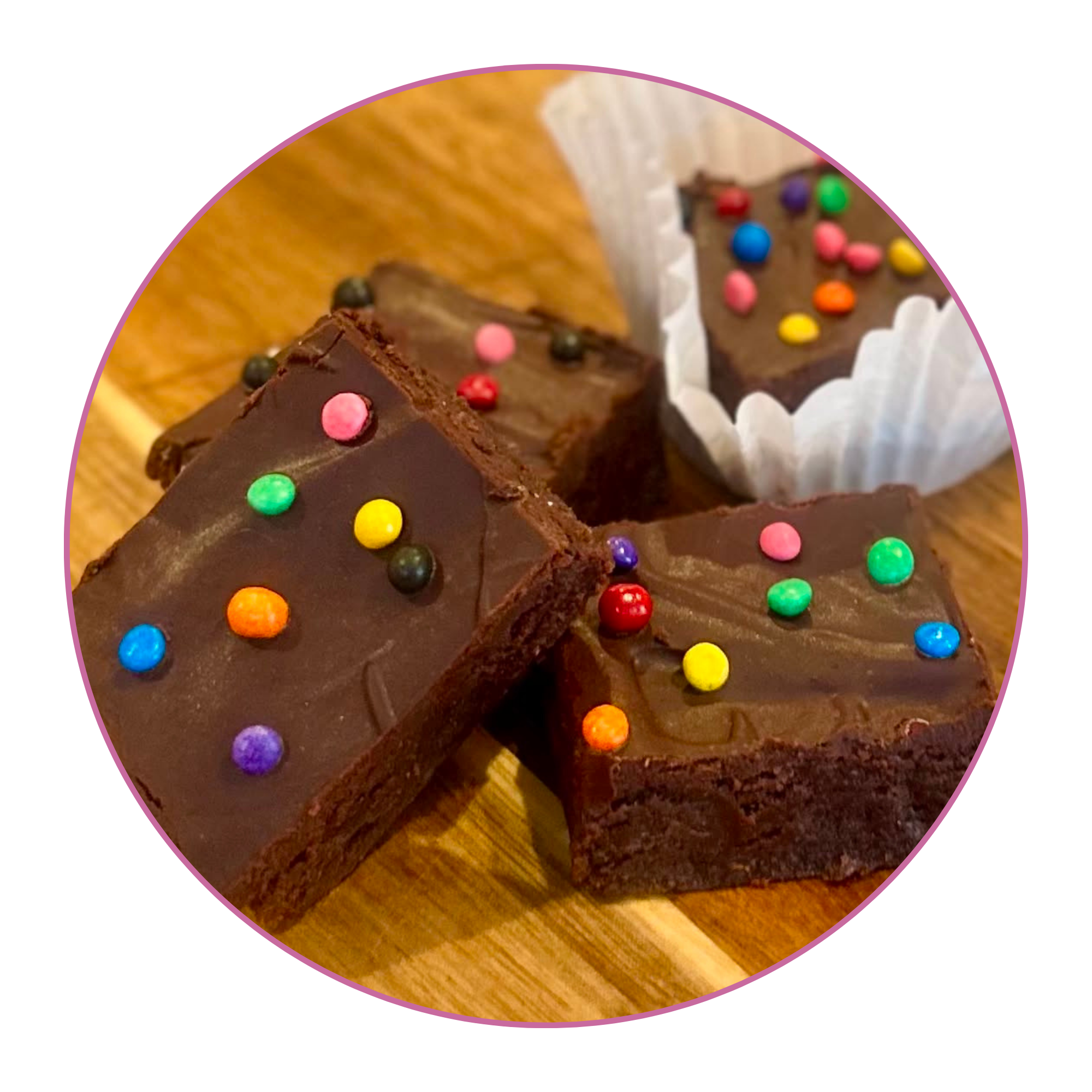 Close-up of decorated chocolate brownies with colorful sprinkles on top, on a wooden surface.