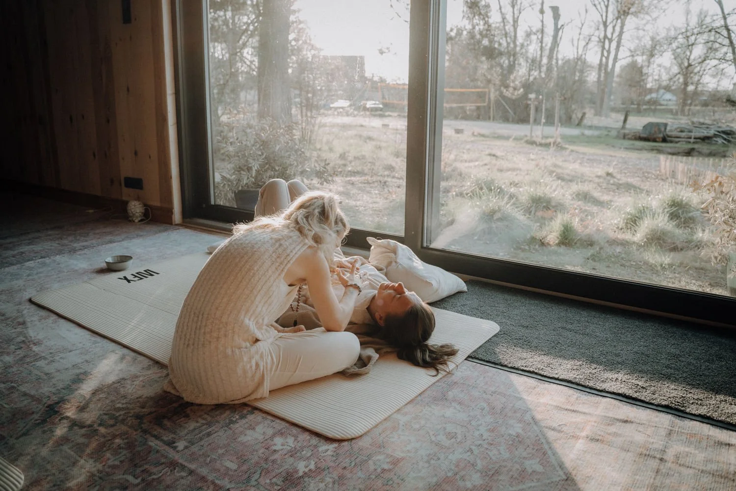 Jeanie Jadias guiding a participant at her Breath & Glow retreat in Berlin with somatic breathwork and EMR, helping them move from survival mode to BERN state for nervous system regulation and self-connection.