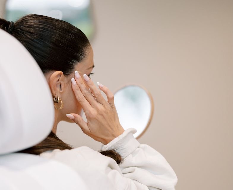 Three dollops of skincare cream or lotion, with the central dollop being beige and the outer two white, displayed on a white background.