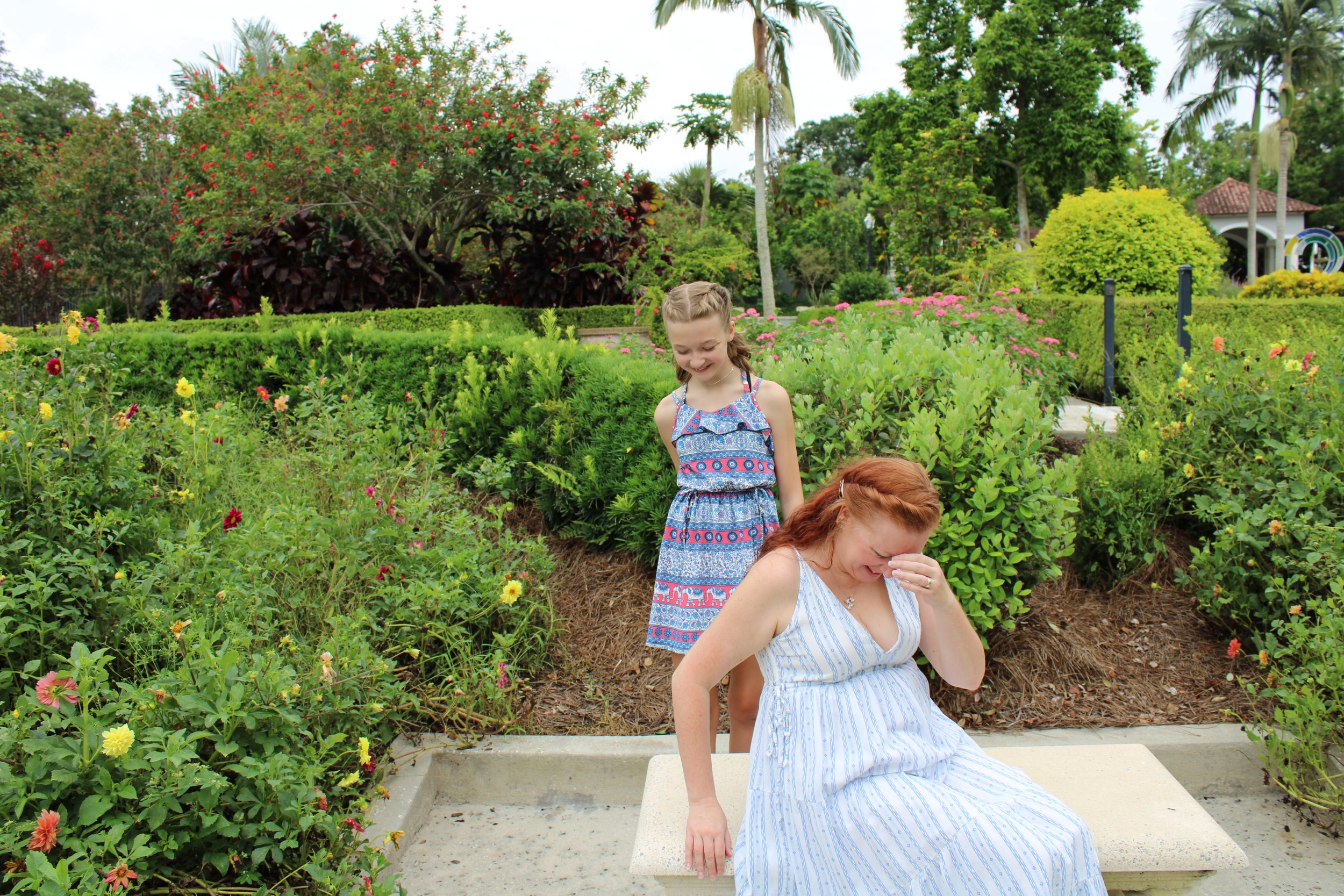 Mother and daughter sitting on bench in a garden