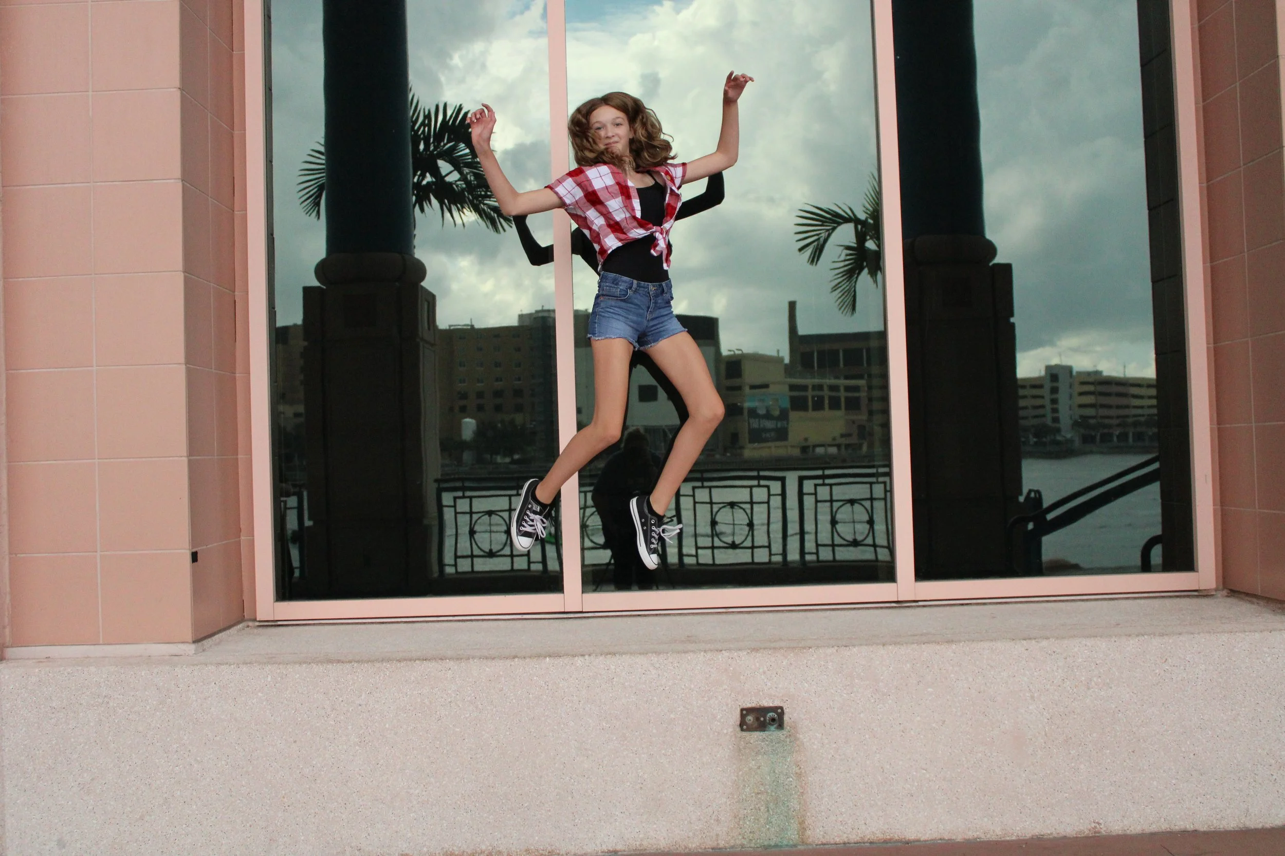a girl jumping in front of a window