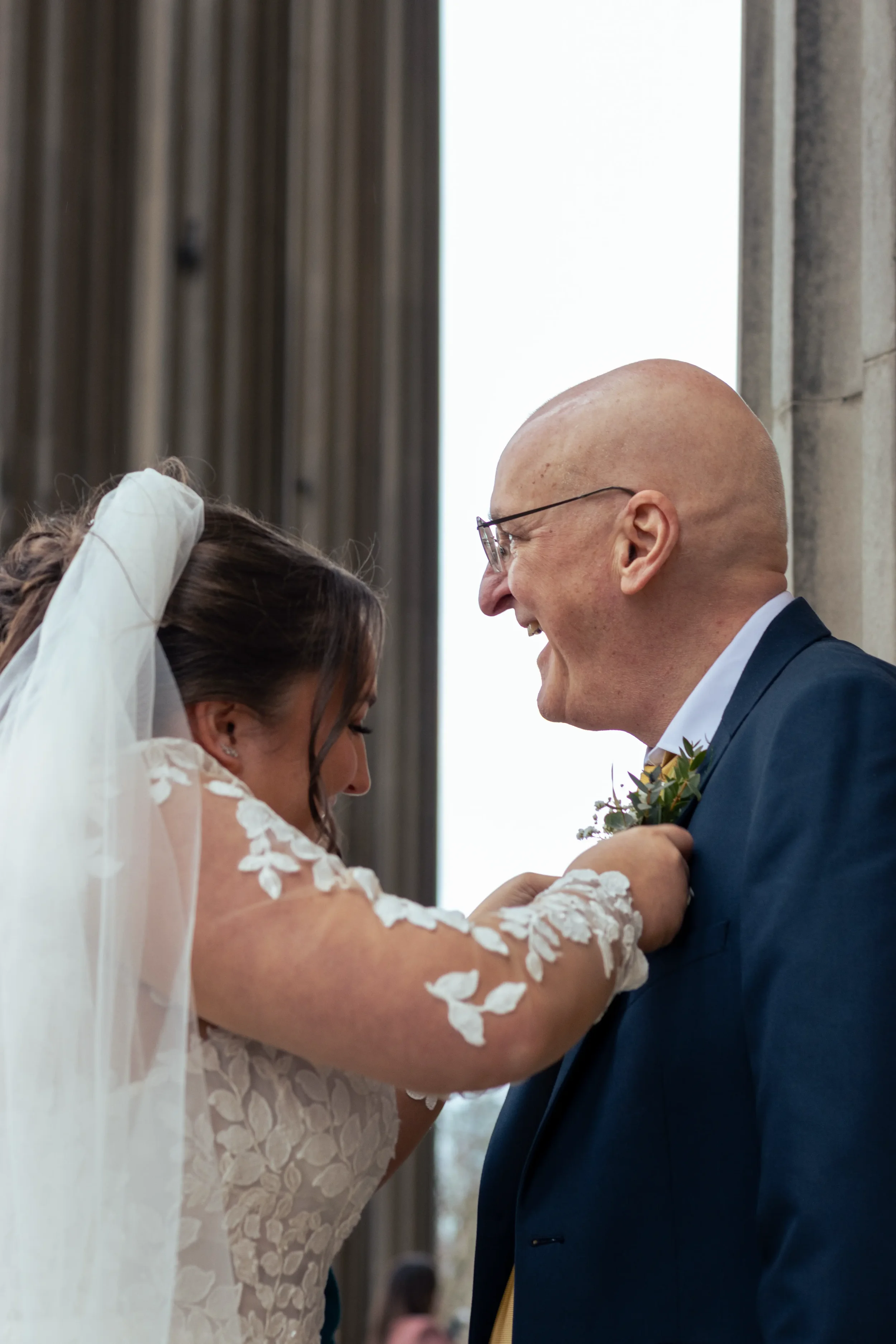 bride attaching her father's boutonnaire.webp