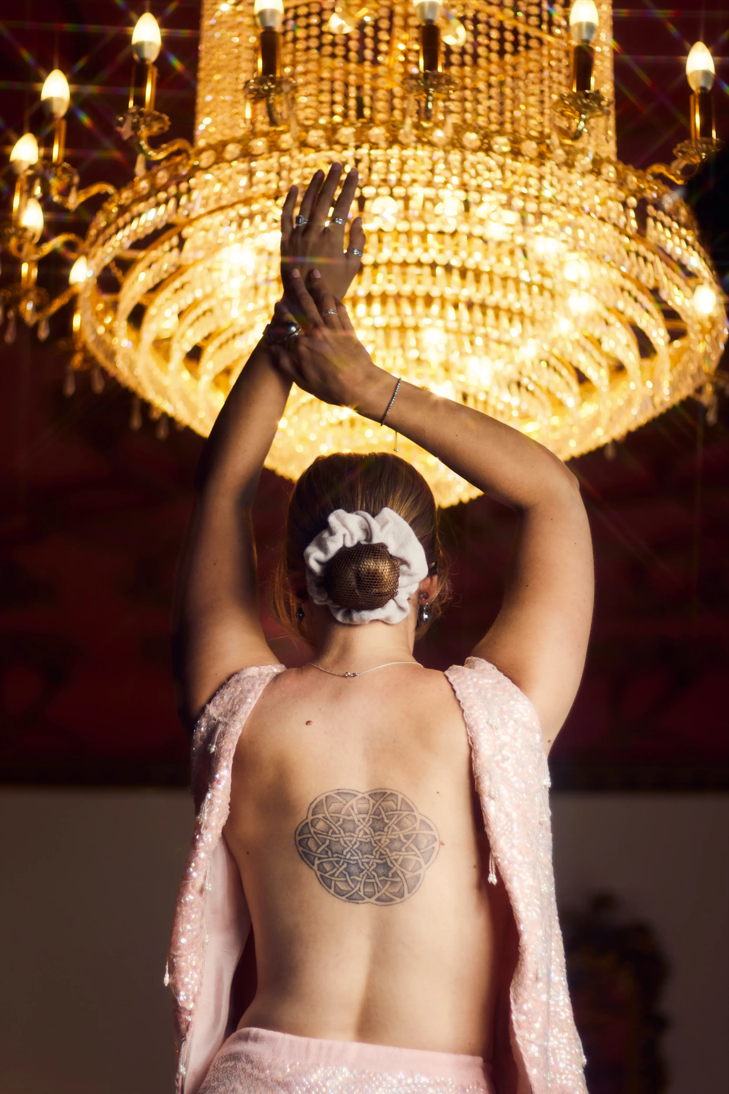lady-in-pink-sequined-backless-two-piece- fashion-photoshoot- framed-by-golden-chandelier-ruthin-castle-north-wales