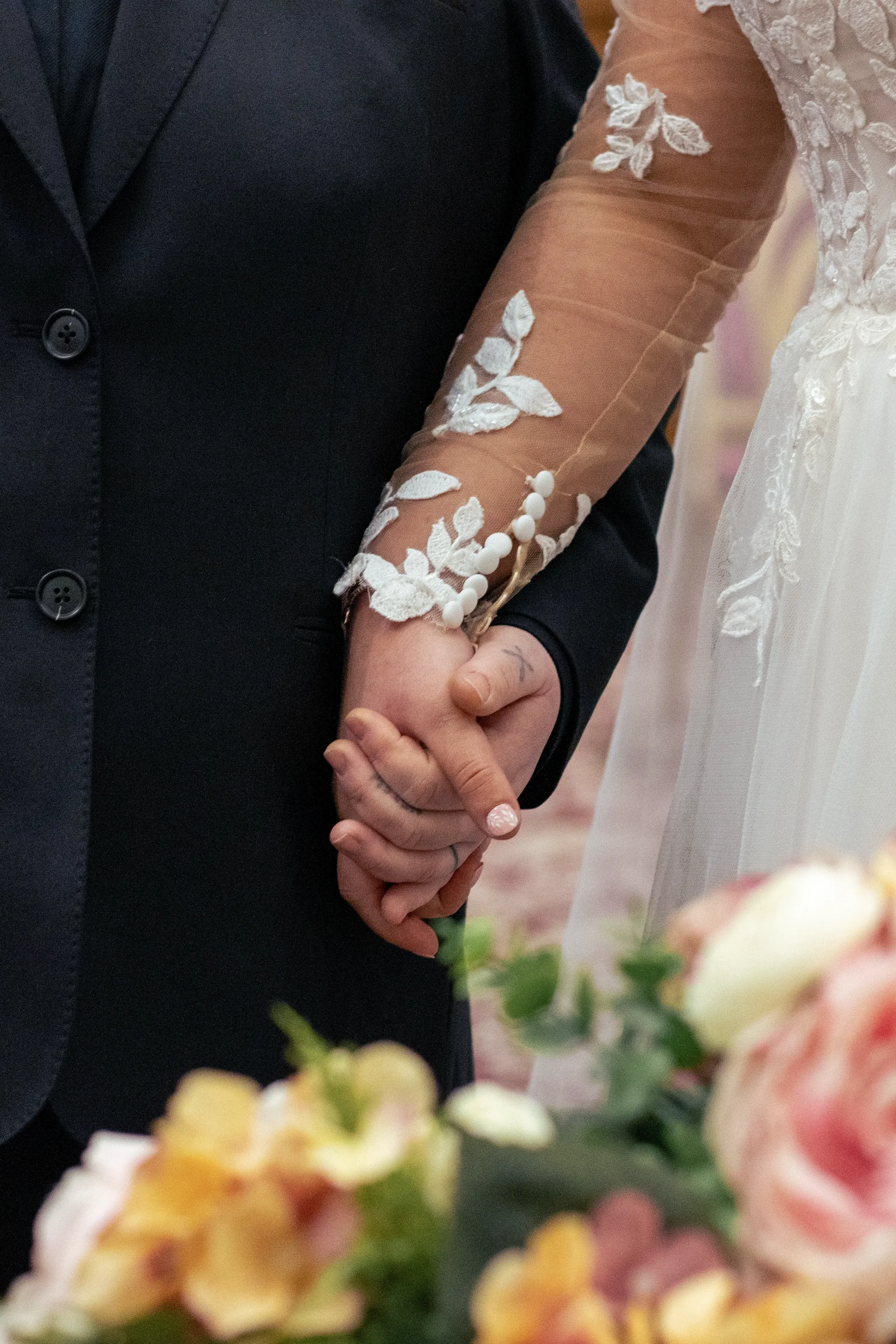 queer brides holding hands during wedding ceremony.webp