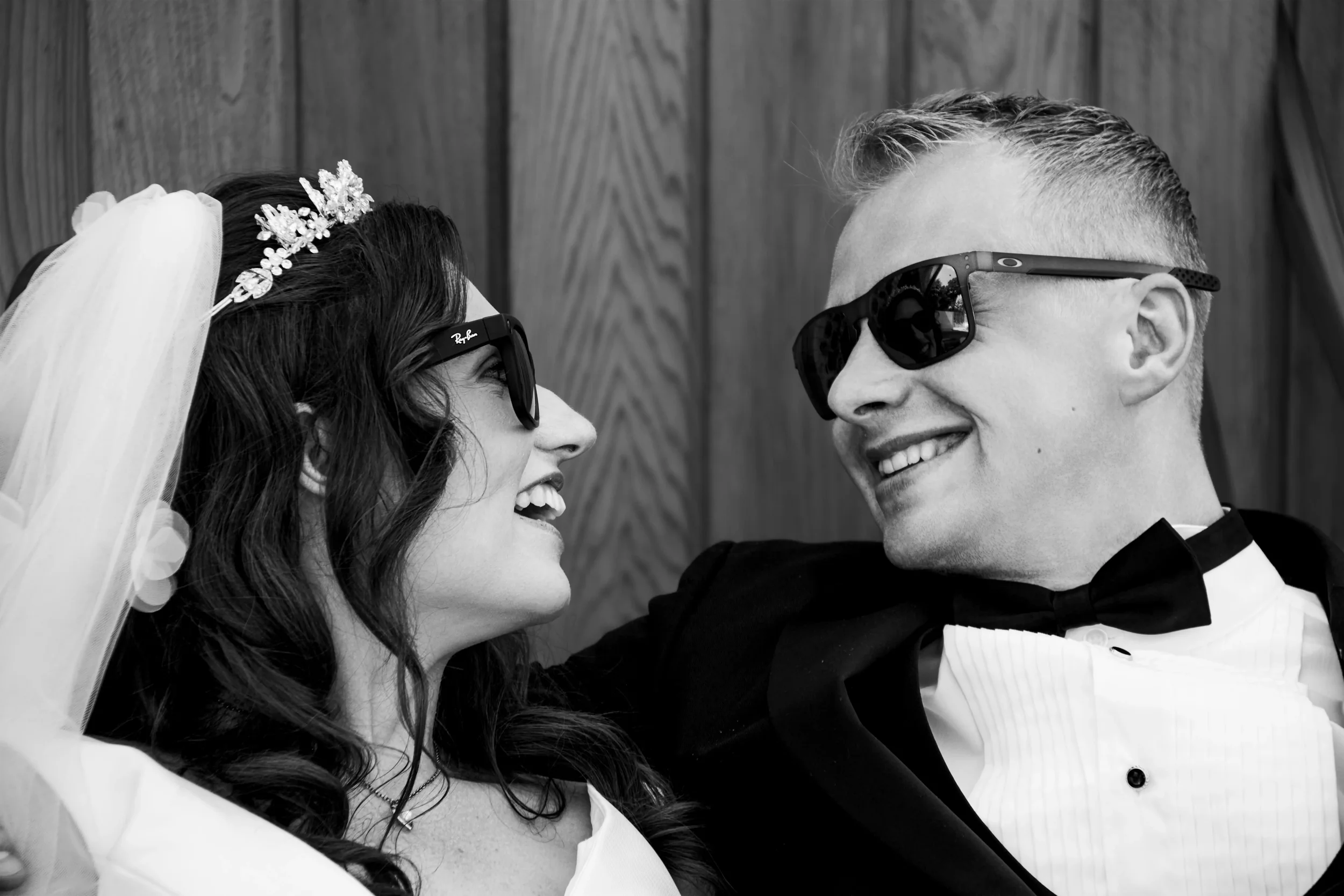 bride-and-groom-in-sunglasses-looking-at each-other-talhenbont-hall-wedding.webp