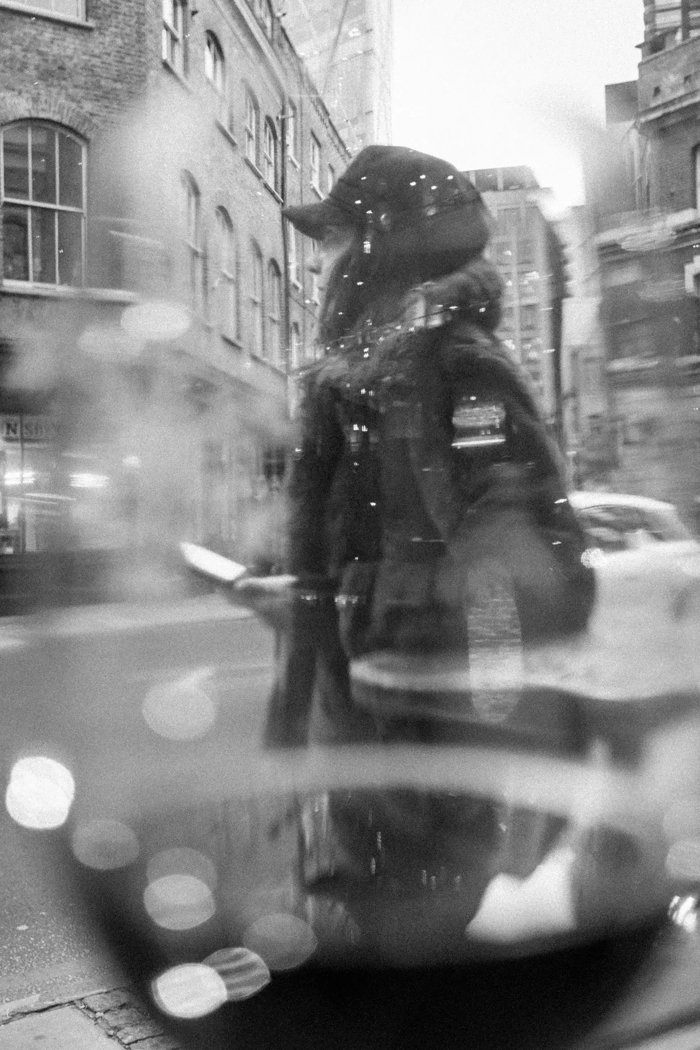 north wales photographer shot of a lady walking past a window of a bar in london shot through a wine glass, with a reflection in the wine.webp