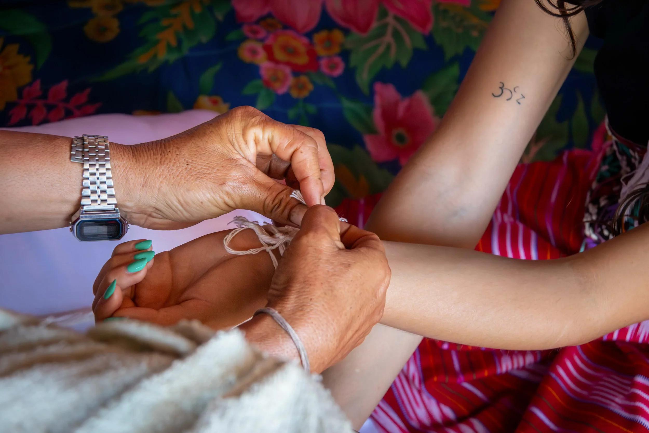 A Buddhist Animist tradition, the Geju ceremony of tying white string around the wrists binds wondering spirits to the body.  