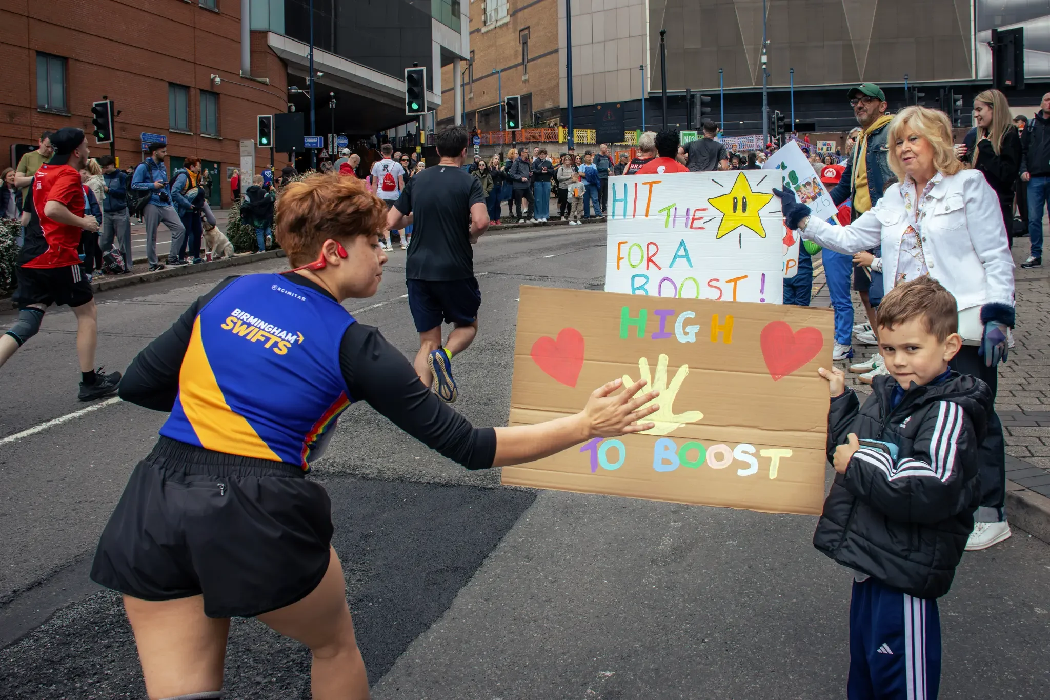 half-marathon-runner-engaging-with-crowd-signs-great-birmingham-run-birmingham.webp