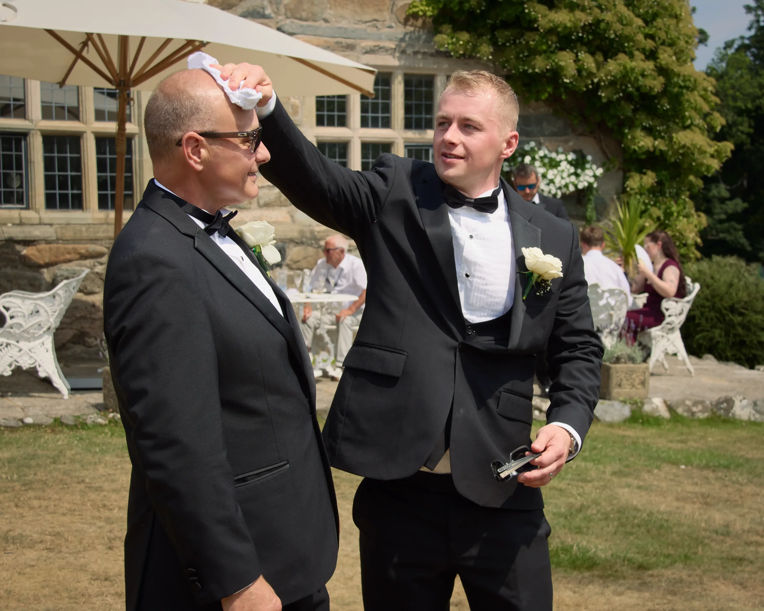 groom-wipes-sweat-from-fathers-brow-talhenbont-hall-wedding.webp