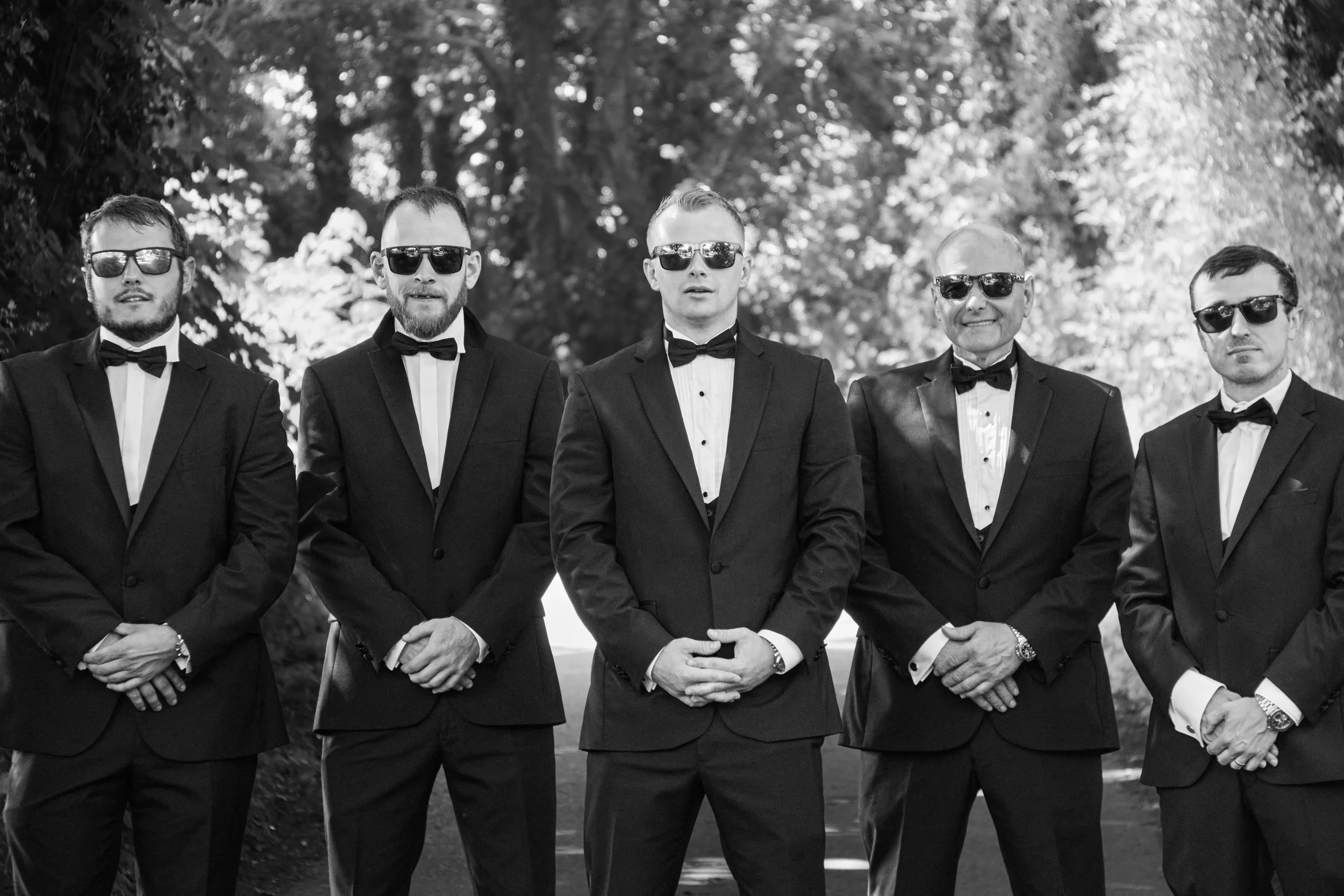 editorial-groomsmen-group-portrait-under-trees-talhenbont-hall-wedding.webp